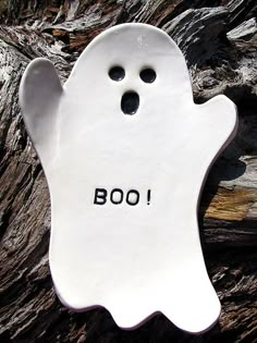 a white ceramic ghost with the word boo written on it