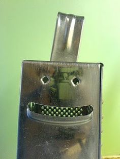 a bag with a face on it sitting on top of a wooden table in front of a green wall