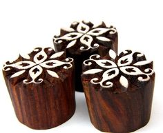 four wooden beads with white designs on them