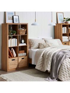 a bed sitting next to a wooden book shelf filled with books and other items on top of a rug