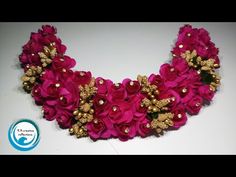 a necklace made with pink flowers and gold beads