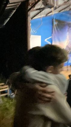 two people hugging each other in front of a stage