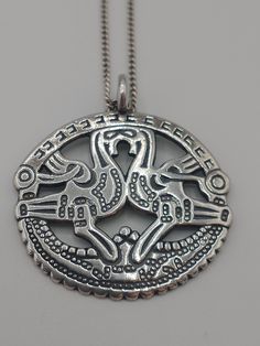 A sterling silver pendant by Kalevala Koru, Helsinki, Finland. It is called Roosters of Kuhmoinen and is based on Viking jewellery found at Papinsaari, Turku, Finland.  It comes with a sterling silver chain. The Finnish company Kalevala Koru is renowned for their interpretations of historic jewellery pieces discovered at archaeological sites. This pendant is a fine example of their jewellery. The pendant is in excellent condition. It is hallmarked KK for Kalevala Koru and 925 for sterling silver Ceremonial Sterling Silver Necklace With Large Pendant, Ceremonial Engraved Sterling Silver Necklaces, Sterling Silver Amulet Necklace With Intricate Design, Sterling Silver Ceremonial Necklace With Round Pendant, Sterling Silver Amulet Necklaces With Intricate Design, Ceremonial Sterling Silver Necklace With Round Pendant, Sterling Silver Necklace With Round Pendant For Ceremonial Occasions, Sterling Silver Round Pendant Necklace For Ceremonies, Ceremonial Sterling Silver Amulet Jewelry