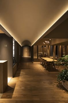 an empty dining room with wooden floors and lighting on the ceiling is lit by recessed lights