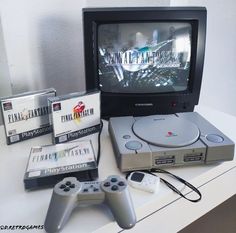 an entertainment system sitting on top of a table next to two video game controllers and games