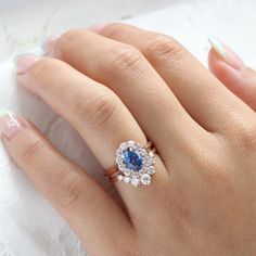 a woman's hand with a ring on it and a blue stone in the middle