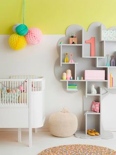 a baby's room with shelves, crib and toys on the wall next to it