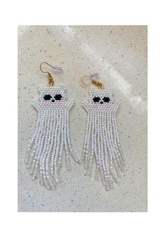 two pairs of white beaded earrings with black eyes