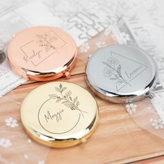 three personalized compact mirrors sitting on top of a table