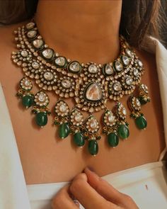 **Description This exquisite Sabyasachi-inspired green-colored grand uncut kundan necklace set embodies timeless elegance and opulence. Featuring a stunning array of uncut kundan stones, the necklace radiates a luxurious green hue that is both captivating and rich. The intricate craftsmanship showcases traditional Indian artistry, with each kundan meticulously set to create a dazzling effect. The set includes a matching pair of earrings that complement the necklace, making it a perfect choice for bridal wear or any special occasion where you want to make a statement. **Care Instructions 1. **Avoid Exposure to Chemicals Keep the necklace and earrings away from perfumes, hairsprays, and other chemicals that may tarnish or damage the stones and metal. 2. **Store Properly Store the jewelry in Luxury Gold Plated Kundan Necklace For Reception, Luxury Festive Kundan Necklace Gift, Luxury Kundan Emerald Necklace For Ceremonial Occasions, Luxury Kundan Temple Jewelry Necklace For Festivals, Luxury Kundan Wedding And Engagement Jewellery, Luxury Elegant Kundan Bridal Earrings, Luxury Kundan Temple Jewelry Necklace With Matching Earrings, Luxury Kundan Jeweled Temple Necklace, Luxury Exquisite Kundan Necklace