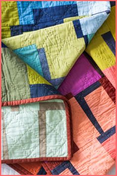 a colorful quilt with an orange frame over it