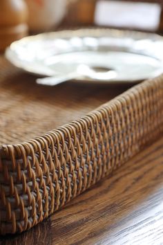 a plate sitting on top of a wooden table next to a wicker basket and bowl