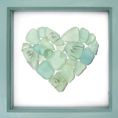 a heart made out of sea glass in a frame