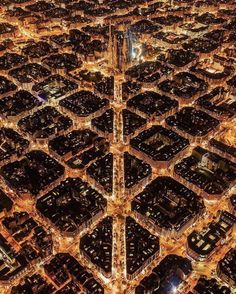 an aerial view of a city at night with lights in the streets and tall buildings