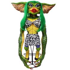 a statue of a woman with green hair and leopard print outfit on top of a metal stand