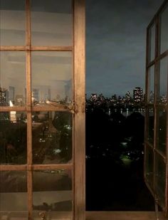 an open window looking out onto a city at night