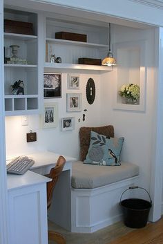 a room with a chair, desk and bookshelf in it's corner