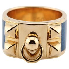 The Hermes Collier de Chien ring is an exquisite piece of jewelry that is both luxurious and elegant. The ring features a beautiful and unique design that is instantly recognizable as Hermes. Crafted from high-quality 18k gold, the ring is durable and designed to last a lifetime. The blue enamel adds a pop of color that is both bold and sophisticated. The enamel is carefully applied by hand, creating a smooth and glossy surface that is both beautiful and durable. The ring is part of the iconic C Luxury Open Ring For Everyday, Luxury Rings With Polished Finish, Luxury Blue Rings With Polished Finish, Designer Everyday Luxury Yellow Gold Rings, Designer Everyday Luxury Ring, Designer 14k Gold Rings, Elegant Yellow Gold Enamel Ring With Polished Finish, Designer Yellow Gold Rings For Everyday Luxury, Luxury Blue Ring Jewelry