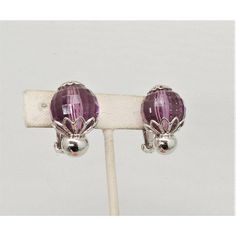 This is part of Chairish’s Costume Jewelry assortment.  Circa 1960 rhodium plated faceted disco ball-like faux-amethyst clip back earrings. Marked "Napier." Measure: 1 1/16 inches long by 13/16 inches wide. Condtion: Very good; a tiny amount of wear only noticeable upon very close inspection.  Please reference the measurements noted in the description above for the best approximate dimensions. Please reach out to the seller under "Ask the Seller" for specific questions regarding the measurements Purple Clip-on Earrings For Formal Occasions, Formal Purple Clip-on Jewelry, Purple Clip-on Earrings, Modern Branding, Accessories Jewelry Earrings, Clip Earrings, Disco Ball, Vintage Signs, Rhodium Plated