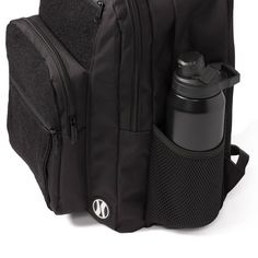 a black backpack with a water bottle in the pocket and an insulated flask