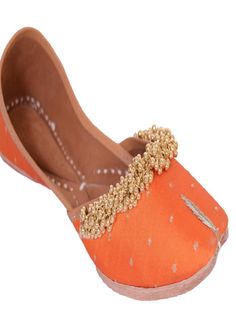 Orange fabric juttis with Gold tiny ghunghroos add a touch of flirty fun to your ensemble with their handiwork and floral pattern. Wear it with a purple and gold sharara set to a friend’s wedding. Color: Orange Fabric: Upper- Silk Embroidered fabric with gold tiny ghungroos, Inner - leather lining cushion for extra comfort & pure leather sole Note: Available in other colors Heel type - Flat The product will be shipped within 20-25 days of the order placed Care intructions - Keep in dust bag, dry Traditional Wear With Gota Work For Designer Occasions, Traditional Wear With Gota Work For Diwali Party, Orange Kundan Traditional Wear, Meenakari Traditional Wear For Navratri Party, Traditional Meenakari Sets For Party, Traditional Wear With Gota Work For Navratri, Handwork Traditional Wear For Diwali, Party Traditional Wear With Gota Work For Festivals, Gold Traditional Wear With Handwork For Navratri