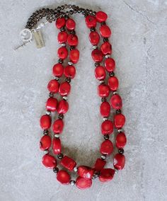 This eye-catching Necklace showcases 2 Strands of Bamboo Coral Oval Nuggets. The Nuggets are a lively coral-red with characteristic black markings, and have been cut with 2 flat sides and a flat round circumference. The structure is both uncommon and attractive. The Coral is slightly graduated — ranging from 11-by-14mm to 14-by-18mm. The stones have been polished to a glossy sheen. We've paired the Coral Nuggets with 17 6mm Oxidized Sterling Silver Rounds, adding subtle shine. The Sterling is co Artisan Red Oval Jewelry, Red Single Strand Long Necklace, Red Oval Jewelry With Natural Stones, Red Oval Natural Stone Jewelry, Red Oval Beads Jewelry, Red Round Artisan Jewelry, Artisan Red Round Jewelry, Traditional Red Oval Jewelry, Red Coral Oval Beads Jewelry