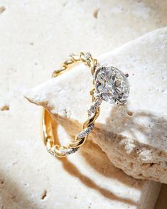 a diamond ring sitting on top of a rock