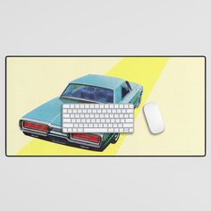 a computer mouse and keyboard sitting on top of a mouse pad with a car design