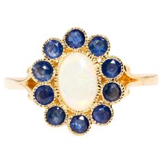 With her stunning opal framed in rich blue sapphires, The Carole Ring is a nod to a glamorous past. Influenced by an era when technicolour reigned in all its vivid glory, she is a must have for todays screen siren. The Carole Ring Gem Details The oval solid Australian opal cabochon displays green and some orange play of colour and measures 7.0x4.7 millimetres. The deep blue sapphires measure approximately 2.5 millimetres. Ring Size P 1/2 (Australia and UK sizing) or 8 (US and Canada). The Carole Opal And Sapphire Ring, All Craft, Australian Opal, Jewelry Rings Engagement, Opal Rings, Deep Blue, Ring Verlobung, Blue Sapphire, Sapphire Ring