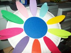 a paper plate that has been made to look like a flower with multicolored petals