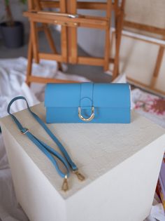 Stunning rectangular bag with a golden buckle and comes with two straps, one short and one long. Whether dressed up or down, this bag is sure to add a touch of elegance to any outfit and is perfect for any occasion. Colors: blue - green - pink Length 11.03 in - Width 1.97 in Contexture: genuine leather Office Rectangular Satchel With Fold Over Clasp, Trendy Office Clutch With Detachable Strap, Elegant Blue Baguette Bag For Evening, Blue Rectangular Flap Bag For Formal Occasions, Square Clutch With Detachable Handle For Travel, Square Travel Clutch With Detachable Handle, Formal Blue Rectangular Flap Bag, Trendy Blue Rectangular Baguette Bag, Chic Rectangular Flap Bag With Detachable Strap