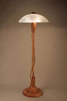 a wooden lamp with a white shade on it's base and a cord wrapped around the bulb