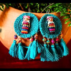 a pair of colorful earrings with tassels hanging from it's ear ends