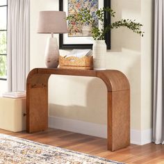 a wooden console table with a lamp on top