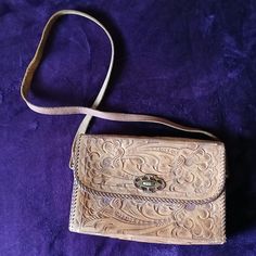 1960s hand tooled leather bag. Floral design. Lots of stains inside but solid purse that can be cleaned. I didn't want to risk damaging it. There is some cracking on the top of the purse as pictured. Vintage Embossed Satchel For Everyday Use, Vintage Leather Embossed Shoulder Bag, Vintage Embossed Leather Shoulder Bag, Vintage Leather Shoulder Bag With Embossed Details, Vintage Brown Embossed Shoulder Bag, Vintage Embossed Satchel Bag, Vintage Brown Embossed Satchel, Vintage Brown Hand Tooled Rectangular Shoulder Bag, Vintage Brown Rectangular Hand Tooled Shoulder Bag