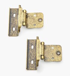 two antique brass plated door hinges against a white background