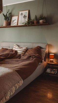 a bed sitting in a bedroom next to a window with plants on top of it