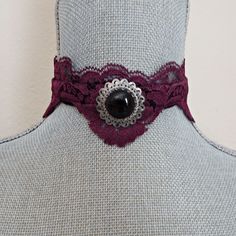 Lovely Victorian look choker features a wine color purple vintage lace combined with black velvet ribbon.  The attached focal on the choker is an antique silver ornate circular setting with a black glass cabochon.  Ribbon is crimped with matching silver metal bars and there is an extension chain for adjustable neck measurement between 13 " and 15". There is a silver leaf bead dangle on the extension chain and a lobster claw closure for the choker.   The velvet ribbon is 5/8" wide and the lace has scalloped edging measuring 1"- 2" width. The silver focal measures 1 1/4" diameter. Gothic Costume, Black Velvet Ribbon, Black Lace Choker, Purple Vintage, Lace Choker, Wine Color, Choker Collar, Wine Colored, Choker Necklaces