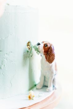 a dog figurine sitting on top of a cake