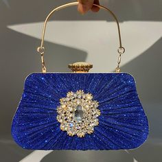 LOW STOCK WARNING Stand out from the crowd with the Anya Pleated Craft Rhinestone Handbag. It features a pleated design and a sophisticated embellishment on the front giving it an overall elegant look. This handbag has ample space for your essentials and is the perfect choice for any woman who loves luxury. Now available in blue, gold, black, and silver. Blue Evening Bag With Rhinestones, Embellished Bags For Gala, Crystal Embellished Bags For Gala, Rectangular Gala Bag With Rhinestones, Glamorous Crystal-embellished Bags For Gala, Elegant Rhinestone Shoulder Evening Bag, Chic Rhinestone Gala Bags, Elegant Blue Embellished Shoulder Bag, Elegant Blue Bag For Night Out