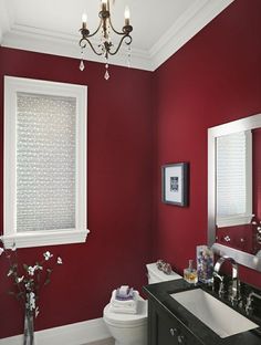 a bathroom with red walls, white trim and black counter tops is featured on pinterest