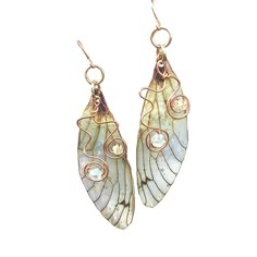 Ethereal Fairy Wing Earrings Delicate and magical are the only way to describe these pretty Cicada wing earrings. A 2 inch long wing with a drop of 2.25 inches,they dangle so lightly being made from translucent plastic.  They are so light you won't even know you are wearing them!  A touch of sparkle is added to the wing with  holographic glitter that gives a special touch of magic to the fairy earrings. Two crystals that match the color of the wing dance upon copper wire swirls th Fantasy Accessories Earrings, Cheap Whimsical Metal Jewelry, Whimsical Cheap Metal Jewelry, Cute Fairy Earrings, Gold Fairycore Drop Earrings, Fae Wings, Earrings Wing, Wire Swirls, Buterfly Wing Earrings