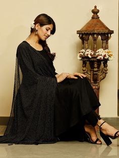 Gorgeous Rayon Solid Suit Set with 3/4th Sleeve Length and a Round Neck Pattern. A Solid Jet Black Flared Kurta and Trouser are Paired with Black Golden Dotted Dupatta Suit Set. Neck: Round Neck Sleeve Length: 3/4th Sleeves Kurta Length: Calf Length Fabric: Kurta & Botton - Rayon Dupatta - Nazmin Gold Funda Note: Wash Care Instructions - Dry Clean Only. The product will be shipped within 15-20 days of the order placed Measurements: Size Bust Waist Hip XS 34 28 36 Size 36 30 38 M 38 32 40 L 40 34 Black Palazzo Set With Sheer Dupatta, Black Anarkali Palazzo Set With Sheer Dupatta, Black Anarkali Set With Straight Kurta, Bollywood Style Black Palazzo Set With Sheer Dupatta, Black Blouse With Sheer Dupatta For Navratri, Black Kurta With Sheer Dupatta For Navratri, Black Sheer Dupatta Blouse For Navratri, Navratri Black Kurta With Sheer Dupatta, Black Traditional Drape Palazzo Set For Navratri