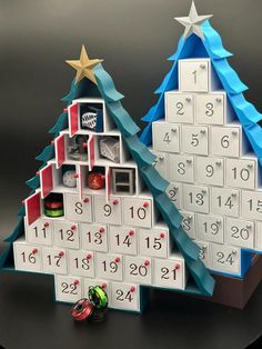 two christmas trees made out of calendars on a table