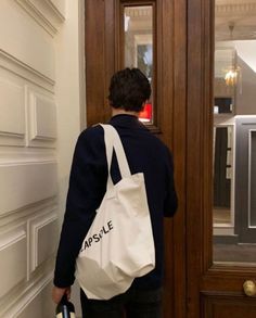 a person standing in front of a door with a bag on their back and the word capsule written on it