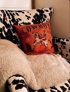 a cow print chair with a pillow on it