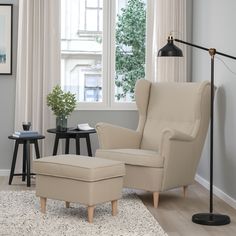 a living room scene with focus on the chair and footstool