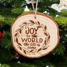 a wooden ornament hanging from a christmas tree with the words joy to the world on it