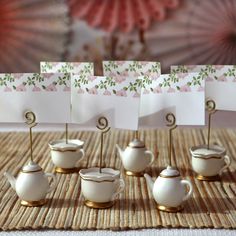 there are tea cups and place cards on the table