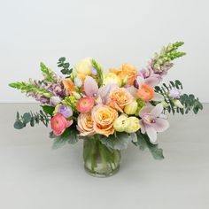 a vase filled with lots of different colored flowers